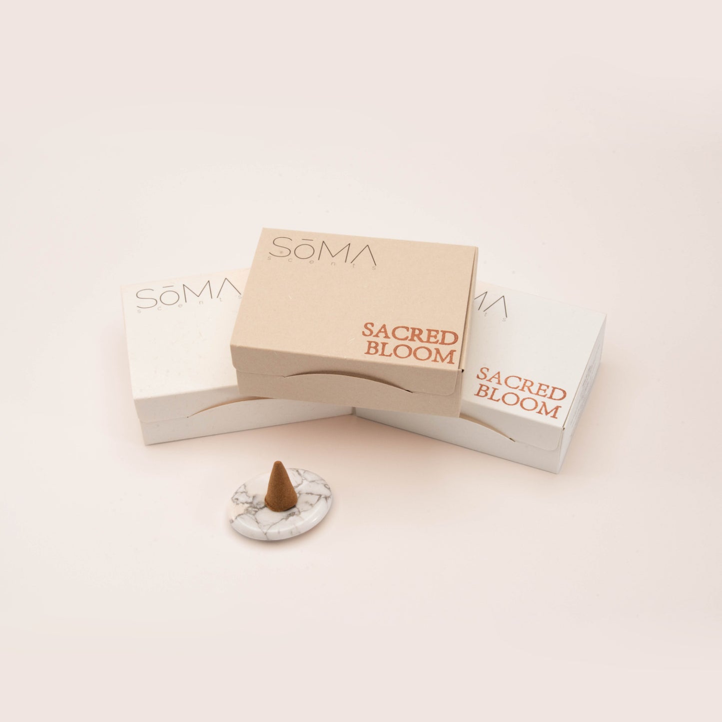 SomaScents incense cone set with minimalist white and beige packaging, displayed alongside a single cone on a marble-style gemstone holder.