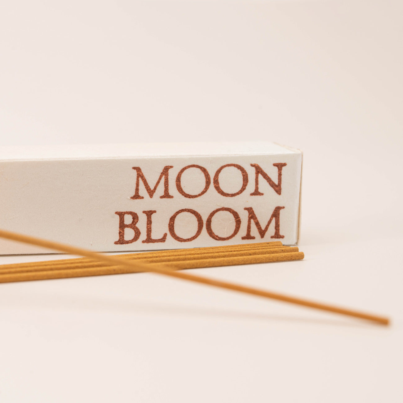 Close-up of SomaScents Moon Bloom incense sticks, displayed on minimalist packaging with a soft, neutral background.