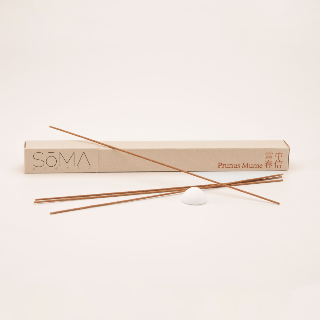 SomaScents Prunus Mume incense sticks with minimalist beige packaging, red Chinese and English text, and a white ceramic holder on a soft neutral background.