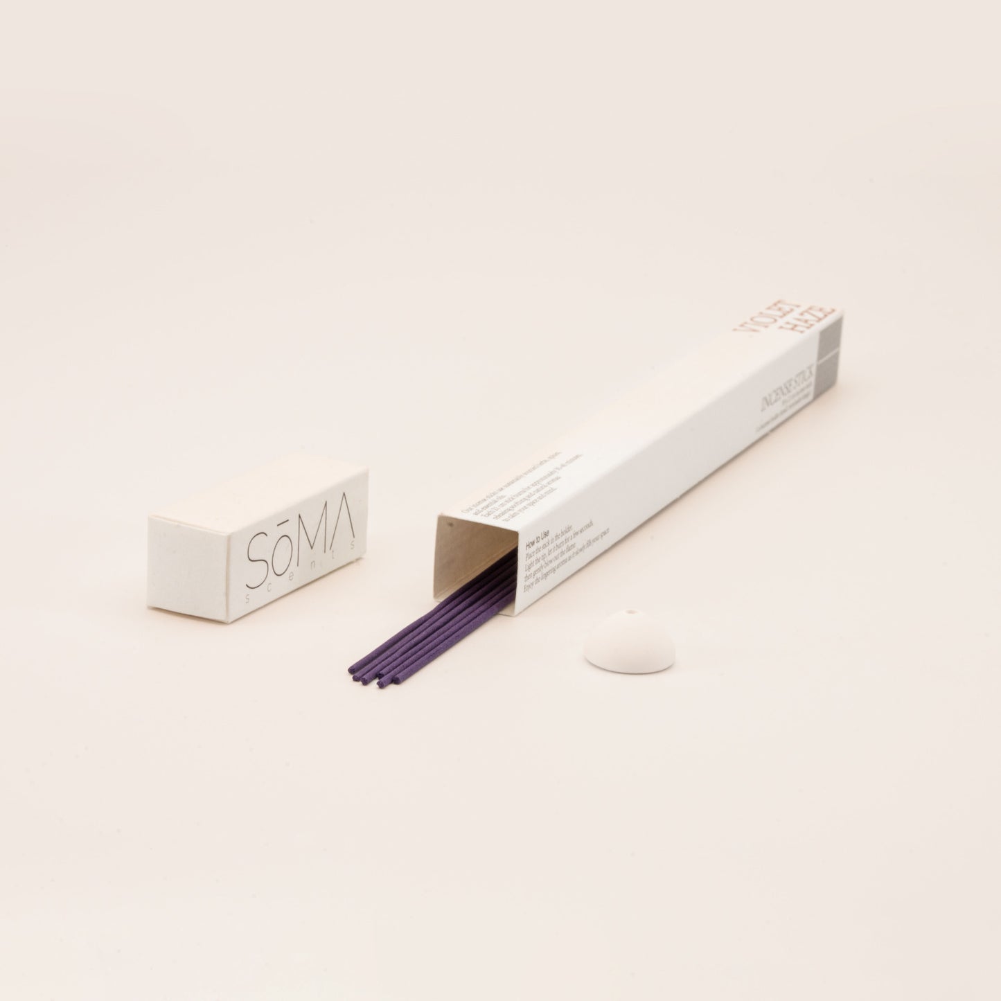 SomaScents Violet Haze incense sticks in white minimalist packaging, displayed with purple incense sticks and a small white ceramic holder