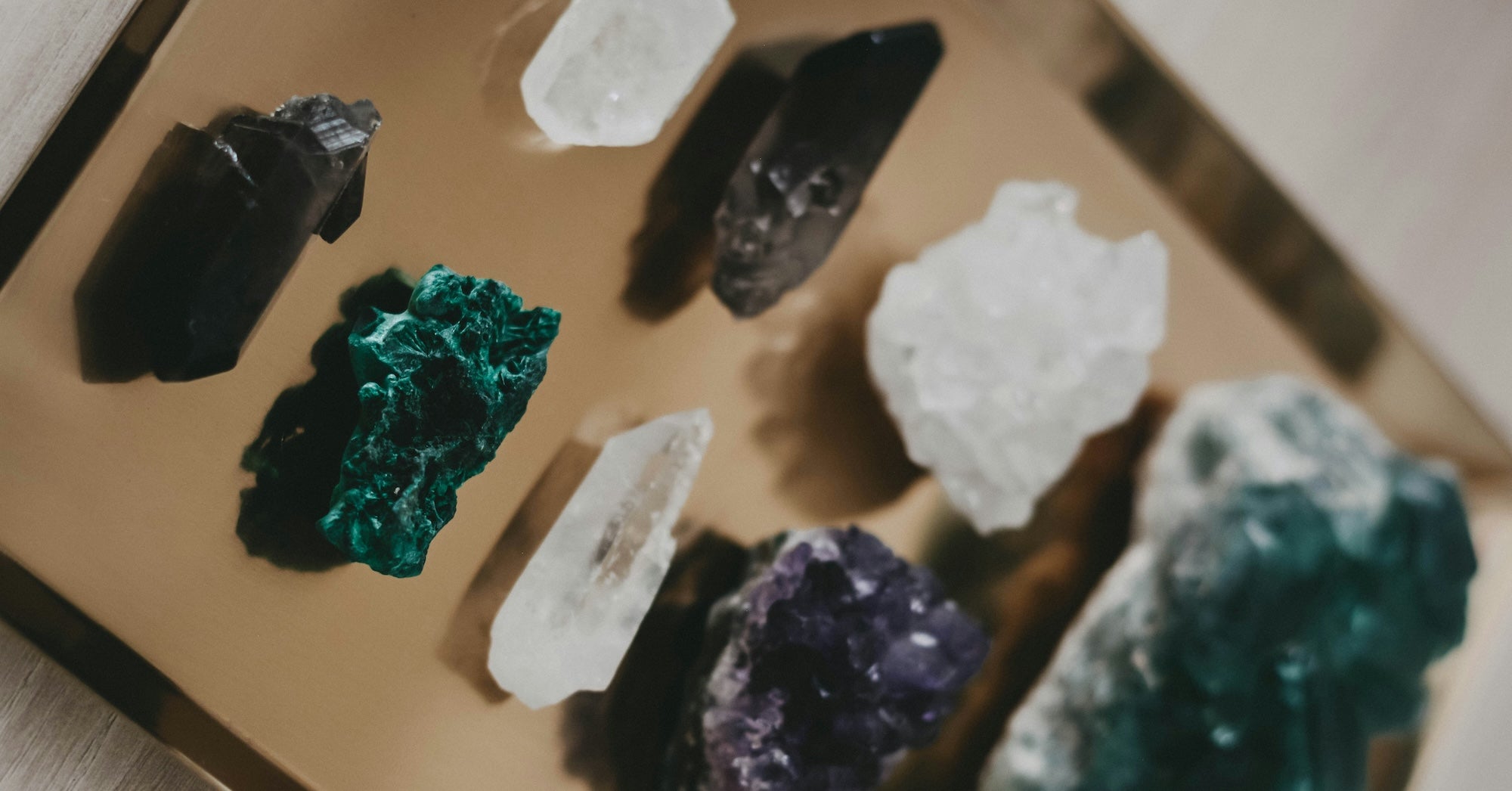 Various colorful crystals displayed on a reflective tray