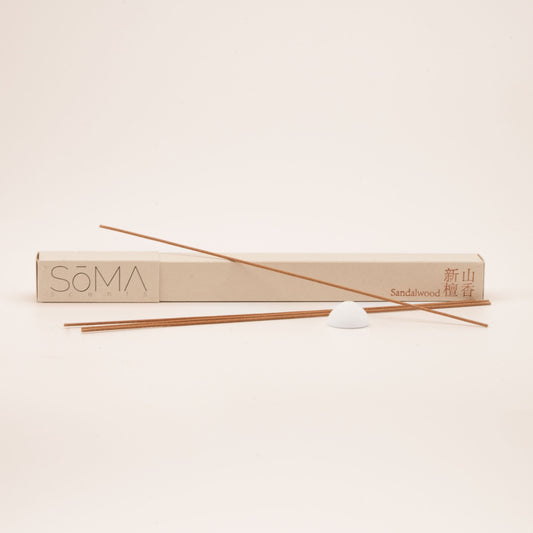 SomaScents Sandalwood incense sticks with beige packaging, red Chinese and English text, and a white ceramic holder on a soft neutral background.