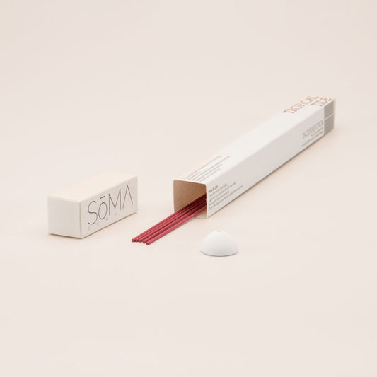 SomaScents Tropical Tide incense sticks in white minimalist packaging, displayed with red incense sticks and a small white ceramic holder